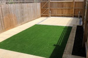 Patio with outdoor lighting, artificial grass with a sleeper flower bed 1