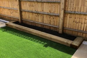Patio with outdoor lighting, artificial grass with a sleeper flower bed 3