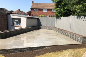Grey Indian sandstone patio with Staffordshire blue brick planters 1