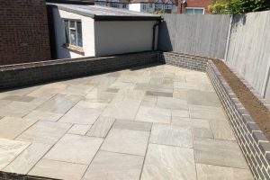 Grey Indian sandstone patio with Staffordshire blue brick planters 2