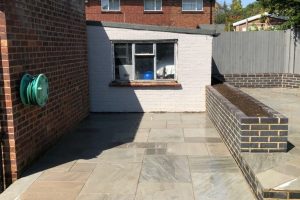 Grey Indian sandstone patio with Staffordshire blue brick planters 4